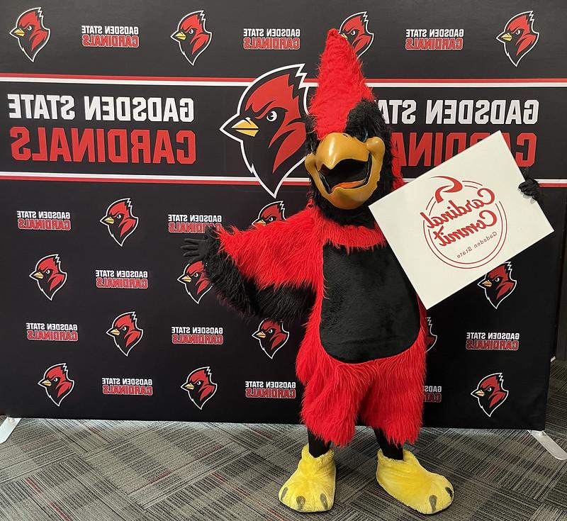 Swoop mascot holding a sign that says Cardinal Commit